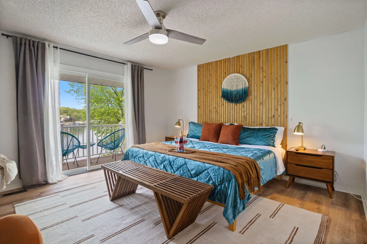 A tranquil bedroom with a bed set against a wood accent wall, soft natural light streaming through the window, and understated, soothing decor. The room feels private and serene, ideal for relaxation and restful sleep.